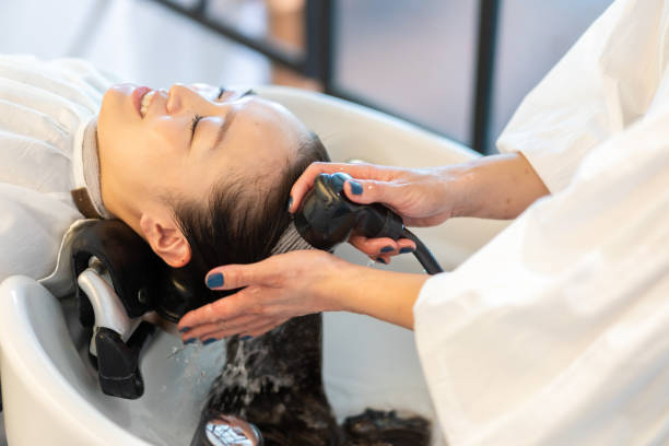 Person getting a hair treatment at a salon with a blurred background
